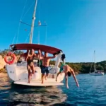 Amigos saltando del barco alquilado en mallorca