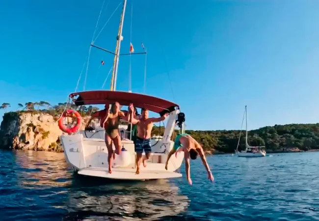 Amigos saltando del barco alquilado en mallorca